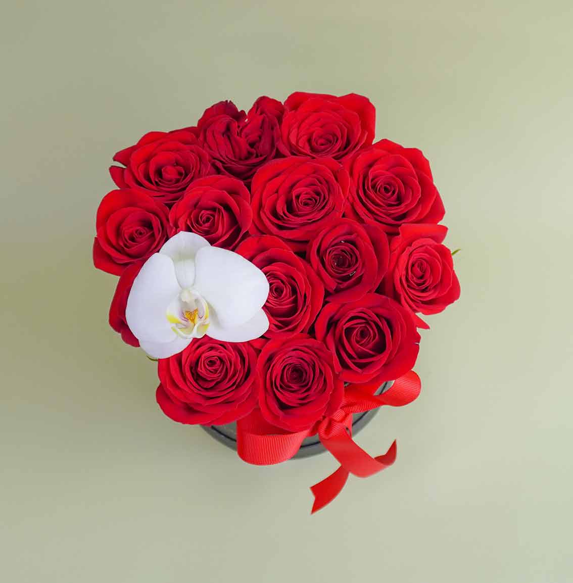 caja de rosas rojas con orquídea