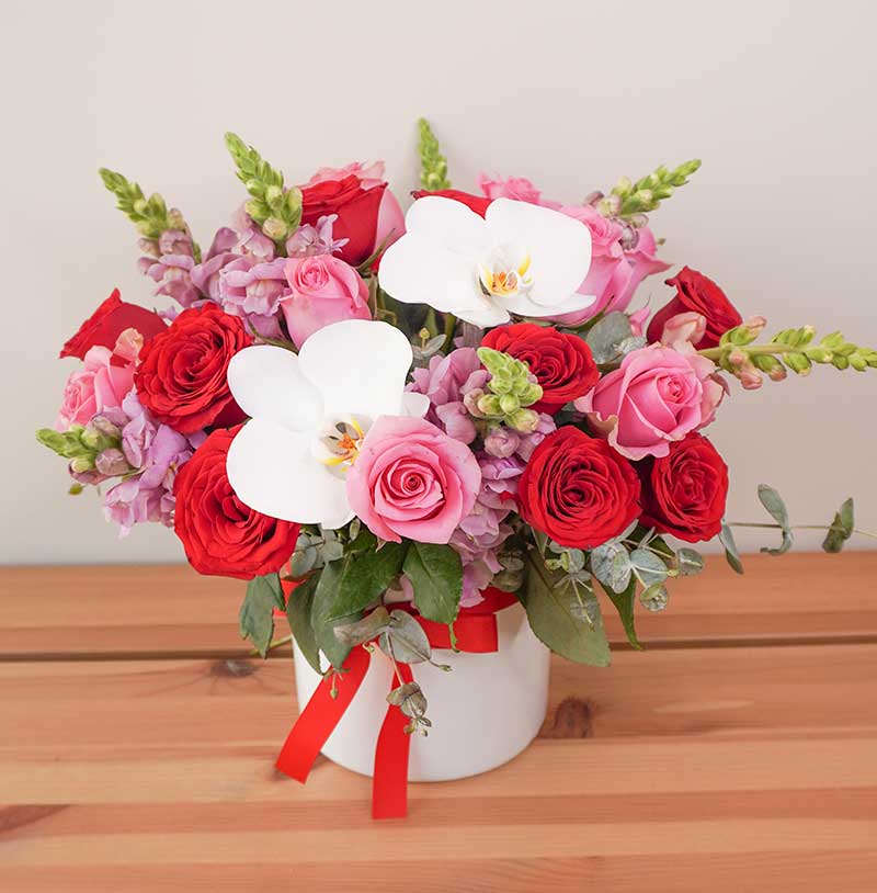envia rosas rojas con flores en florero