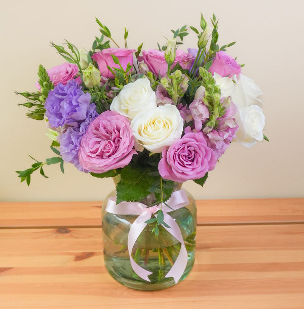 arreglo de flores con rosas moradas y blancas en florero para regalar y enviar el mismo día